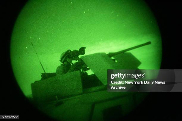 Soldier of the Army's 3rd Brigade, 1st Infantry Division is seen through a night vision scope, as he scans the horizon from a Humvee for possible...