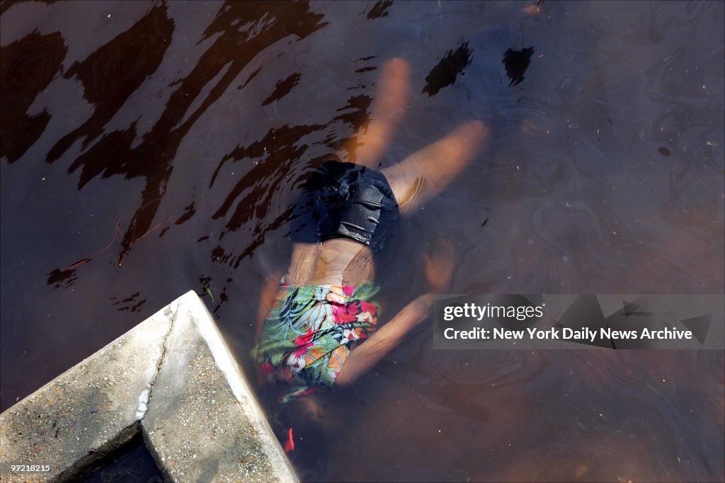 A body floats in brackish water in the flooded street outsid