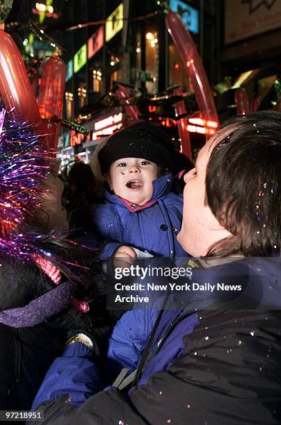 Baby celebrates with his parents as the clock strikes midnight on New Year's Eve in Times Square. About half-a-million New Yorkers and visitors from...