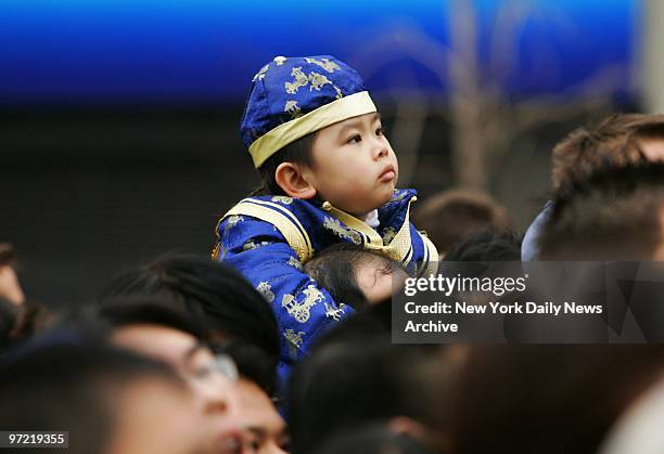 Youngster in festive attire watches during Chinese New Year celebrations at Chatham Square in Chinatown. Today marks the beginning of the Year of the...