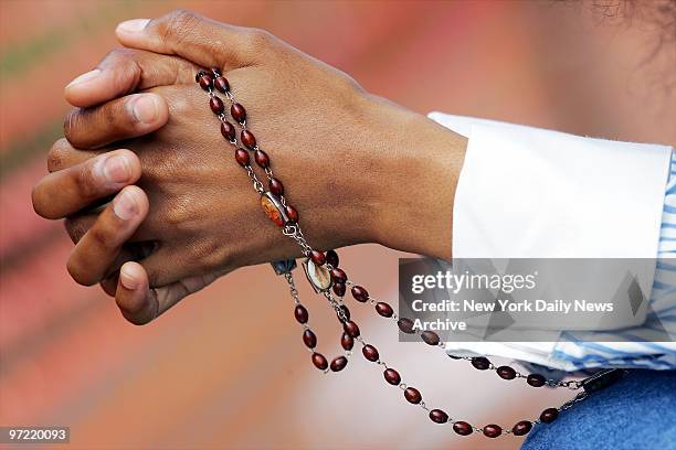 Woman prays with her rosary beads outside the Woodside Hospice in Pinellas Park, Fla., where it has been 11 days since Terri Schiavo's feeding tube...