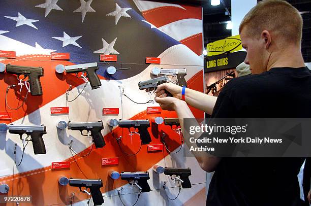 Young man tries out a stainless steel K9098 9-mm steel concealed carry pistol at the Kahr Arms gun display during the National Rifle Association's...