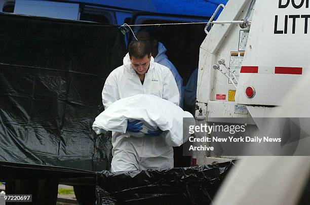 Detective from the crime scene unit, wearing a biohazard suit, cradles the body of a full-term baby girl found in a black plastic bag in the back of...