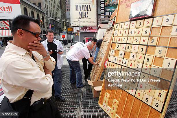 Pascua of Fairlawn, N.J., works on solving a Sudoku puzzle on a gigantic board in Times Square during a nationwide competition sponsored by Sudoku...