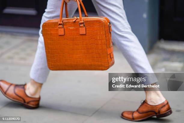 Guest wears an orange crocodile leather bag, during London Fashion Week Men's June 2018 on June 09, 2018 in London, England.