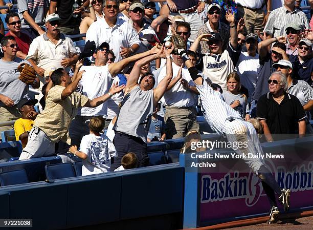 Fan makes the catch before New York Yankees' thrid baseman Aaron Boone can snare a foul ball hit by Carlos Lee in the seventh at Yankee Stadium. The...