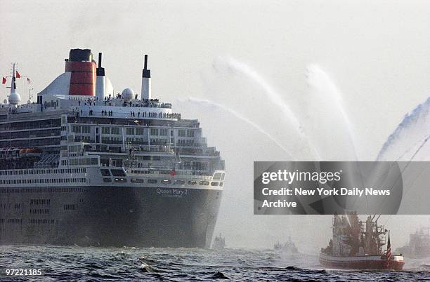 Fireboat provides the traditional water-spouting welcome as the giant luxury liner Queen Mary 2 arrives in New York Harbor after a bumpy, six-day,...