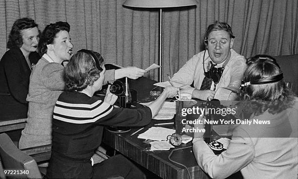 Actor Charles Laughton, surrounded by telephone operators, completes the 16th of 18 consecutive hours he spent on the radio selling war bonds in an...