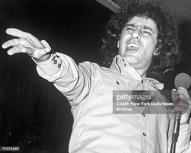 Abbie Hoffman holding a microphone.