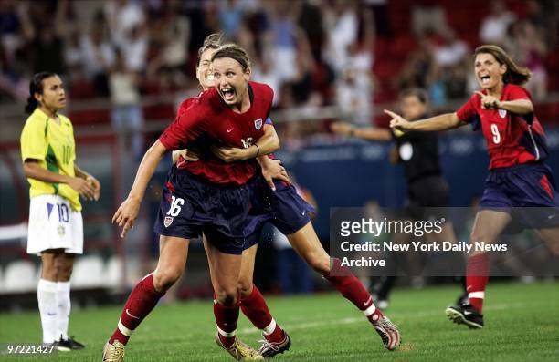 Abby Wambach of the U.S. Is hugged by a teammate after scoring the game-winning goal in overtime against Brazil in the women's soccer gold medal...