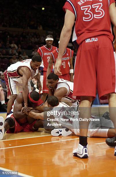 Abe Keita, the St. John's center, is in the middle as Boston College hands reach in from all directions to try to pry a loose ball from his grasp....