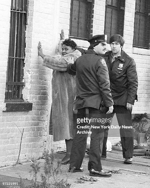 Fur-clad woman and cop wait for matron to search her at social club at 220 Howard Ave. In Bedford-Stuyvesant, Brooklyn. Police responded twice to...
