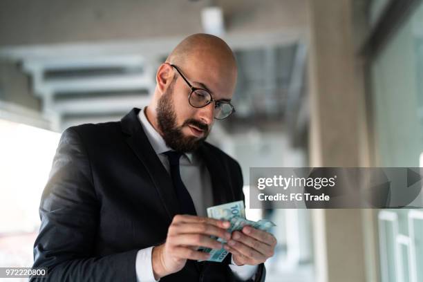 brazilian business man counting brazil currency - real - receiving cash stock pictures, royalty-free photos & images