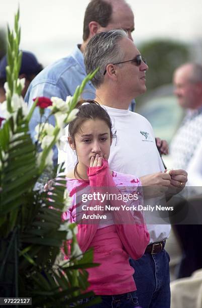 Girl grieves as she stands with others on hand to pay their respects at a makeshift shrine at the entrance to the Johnson Space Center in Houston to...