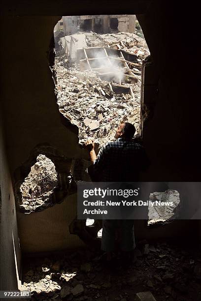 Man looks out at a site in southern Beirut, Lebanon, where Israeli bombs leveled nine residential towers on Sunday hours before the ceasefire was set...