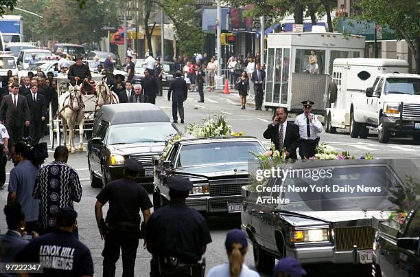 Glass-paneled carriage, pulled by a pair of cream-colored horses, bears the casket of R&B star Aaliyah along Madison Ave. From the Frank E. Campbell...