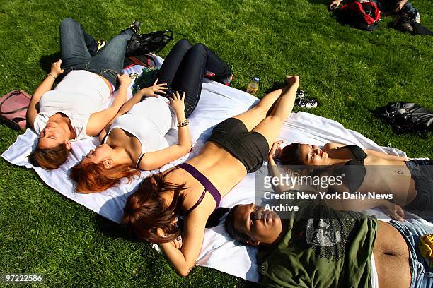 Group of students from the High School of Fashion Industries takes advantage of the beautiful weather to work on their tans in Madison Square Park...