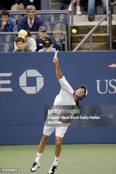 Albert Montanes of Spain serves to Lleyton Hewitt of Australia during the first round of the U.S. Open Men's Singles competition in Louis Armstrong...