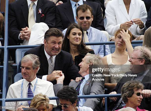 Alec Baldwin clasps hands with a fan as Rick Moranis looks on during a semifinal match between Roger Federer of Switzerland and Tim Henman of Great...