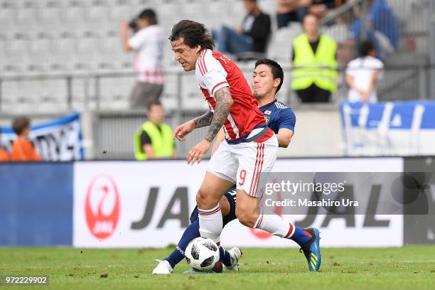 Federico Santander of Paraguay controls the ball under pressure of Gen Shoji of Japan during the international friendly match between Japan and...