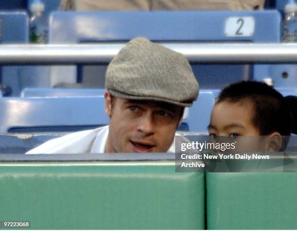 Actor Brad Pitt discusses some of the finer points of baseball with Angelina Jolie's son Maddox, center, at a New York Yankees-Seattle Mariners game...