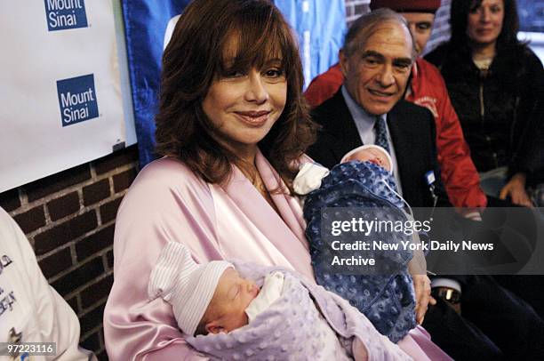 Aleta St. James, holding twins Francesca and Gian, is joined by Dr. Jonathan Scher, who delivered the babies, and her brother, Guardian Angels'...