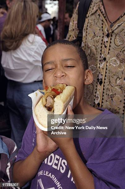 Alex Robinson takes bite of a sausage and pepper sandwich during San Gennaro Festival on Mulberry Street in Little Italy.