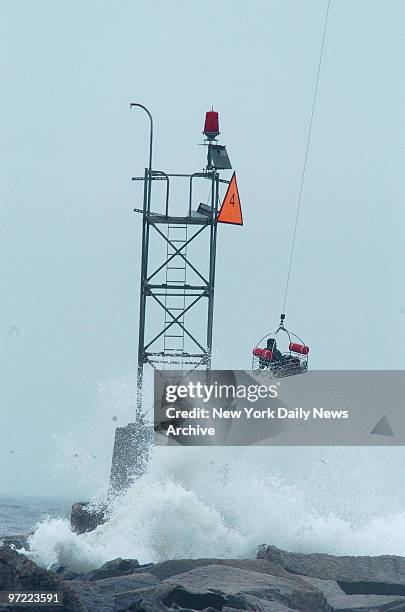 Lift bucket retrieves one of four fishermen stranded on a jetty off Breezy Point, into a police helicopter. Tempted by a school of bluefish, the...