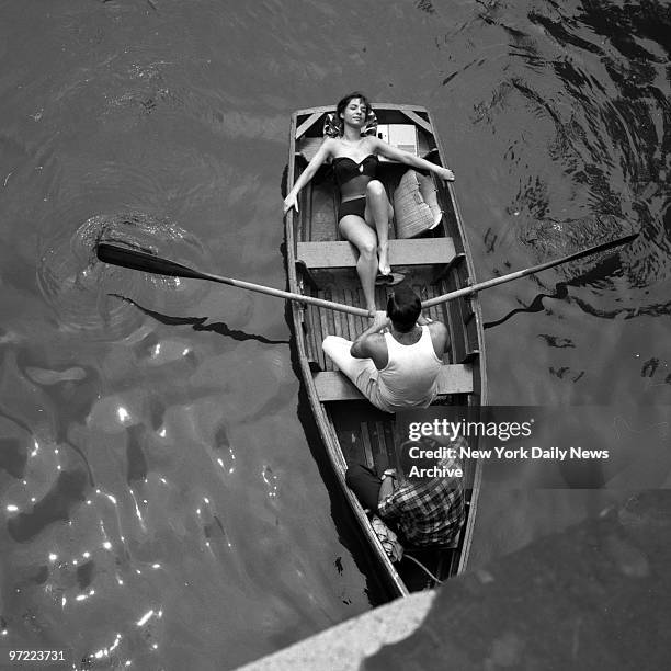 Little like a mini-Cleopatra on a minibarge, Adelita Clark , basks in sun as male admirers supply the muscle power and navigation on Central Park...