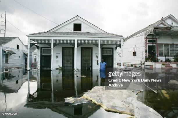 Man stands on the porch of his flooded home in the Mid City neighborhood of New Orleans following the devastation of Hurricane Katrina, which hit the...