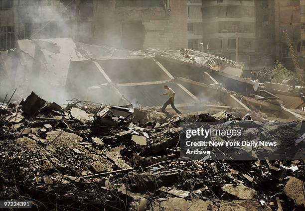 Man walks on rubble at a site in southern Beirut, Lebanon, where Israeli bombs leveled nine residential towers on Sunday hours before the ceasefire...