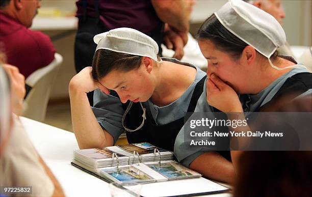 Amish women react with emotion as they look over photographs of Waveland, Miss., as it was before Hurricane Katrina hit during a sharing night for...