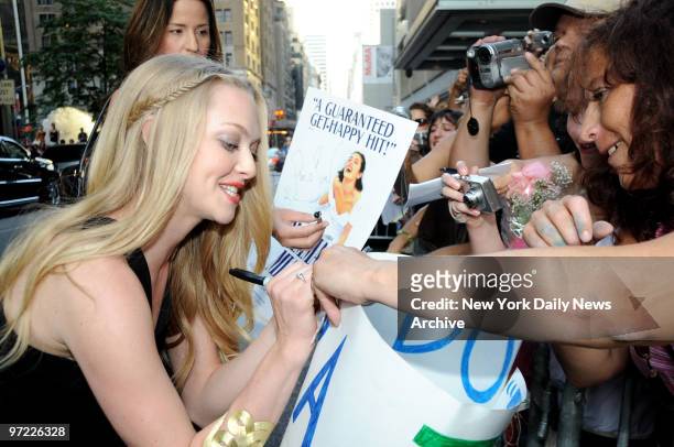 Amanda Seyfried signs autographs for fans at the American Premiere of the movie "Mamma Mia" held at the Ziegfeld Theater