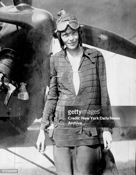 Amelia Earhart in front of plane.