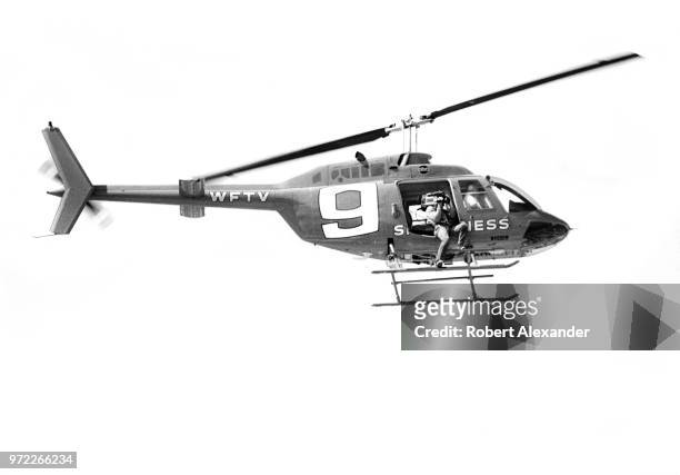 Television news helicopter and cameraman from WFTV in Orlando, Florida, shoot aerial scenes during the running of the 1985 Daytona 500 at Daytona...