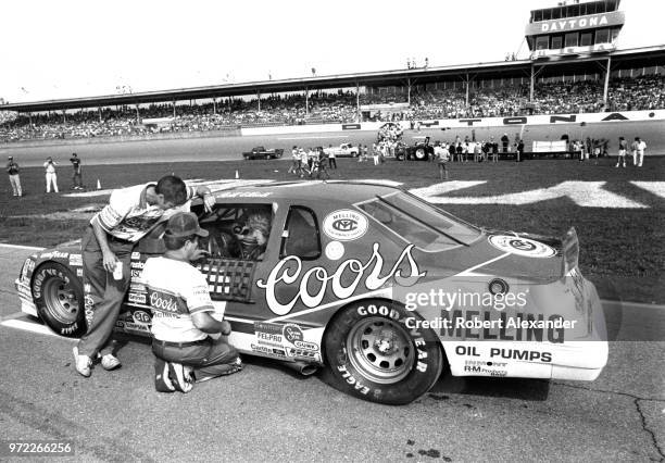 Driver Bill Elliott sits in his racecar and talks with members of his crew prior to the start of the 1985 Daytona 500 at Daytona International...