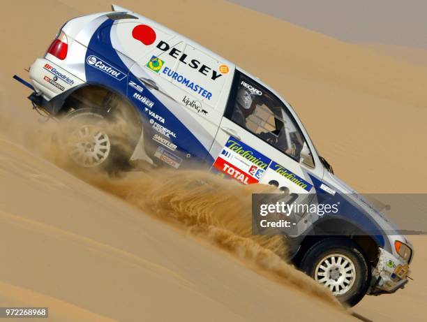 Le pilote français Luc Alphand et son copilote britannique Matthew Stevenson au volant de leur BMW X5, le 12 janvier 2003, dans le désert libyen,...