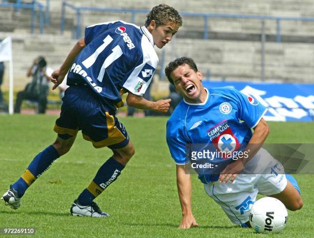 Julio Pinhero of Cruz Azul falls as a result of the block of Jose Luis Lopez of the Pumas of the UNAM during the 10th game of the local Mexican...