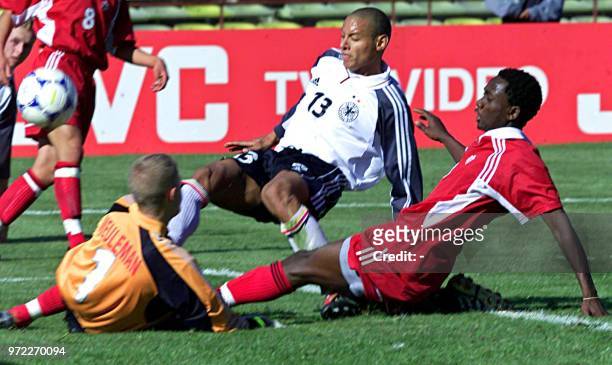 Jermaine Jones , of Germany, fights for the ball with Victor Oppong and the goalkeeper Pieter Meuleman, of Canada, 20 June 2001, during a game for...