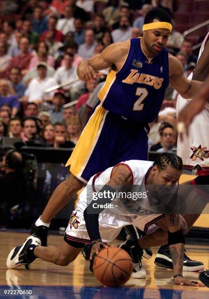 Philadelphia 76ers guard Allen Iverson falls to the floor as he is guarded by Los Angeles Lakers Derek Fisher during the third quarter of game four...