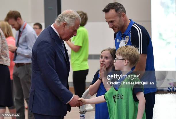 Prince Charles, Prince of Wales speaks with children engaged in sporting activities during a visit to Ulster University's Colraine Campus on June 12,...