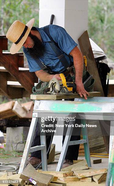 An Amish man works on repairing a home damaged by Hurricane Katrina in Waveland, Miss. A group of Amish people arrived from Lancaster County, Penn.,...