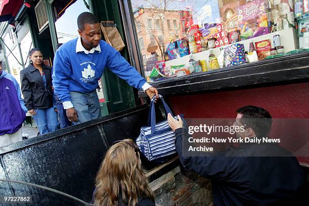 An Animal Care and Control worker hands over a bag of kittens that will be used to lure an 11-month-old black cat out from behind the wall of the...