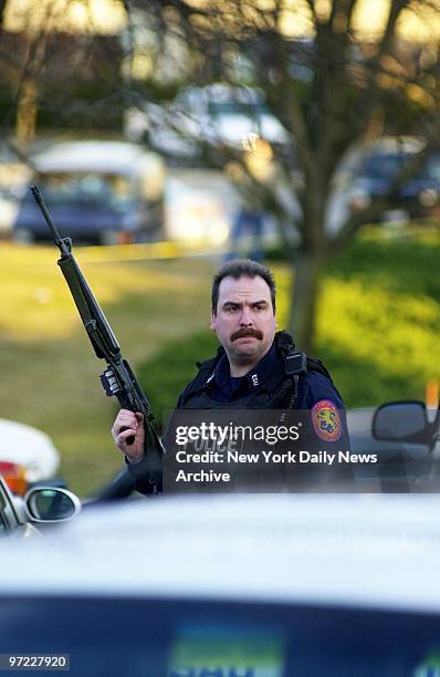 An armed Nassau County police officer stands guard outside the Vanderbilt catering hall in Plainview, L.I., where gunfire and knife fights erupted at...