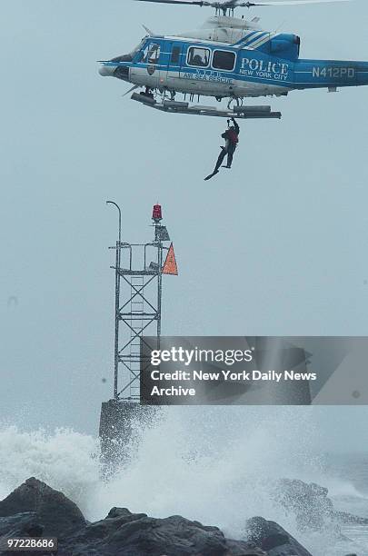 An NYPD scuba diver is winched up to a police helicopter after helping to rescue four fishermen stranded on a jetty off Breezy Point. Tempted by a...