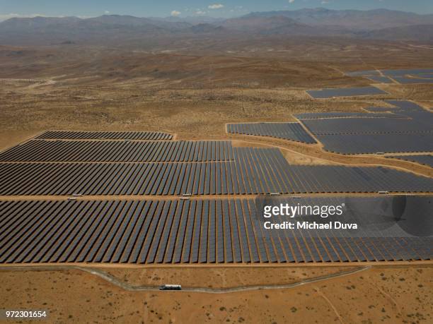 large array of solar panels with mountains in the distance - baggy green stock pictures, royalty-free photos & images