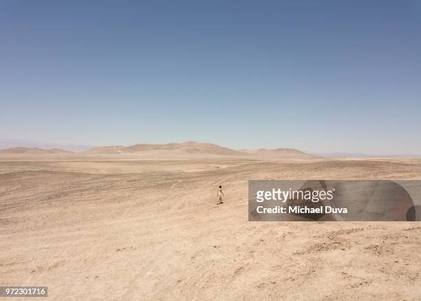 woman out in desert barren landscape with mountains - öde landschaft stock-fotos und bilder