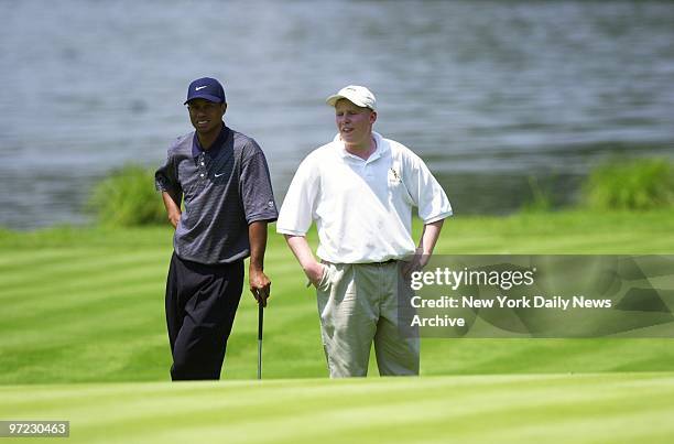 Andrew Giuliani stands alongside as Tiger Woods considers his position on the eighth hole at the Westchester Country Club. The mayor's 15-year-old...