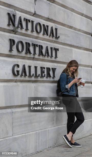 Woman looks at her mobile phone outside the National Portrait Gallery on June 4, 2018 in Washington, D.C. The nation's capital, the sixth largest...
