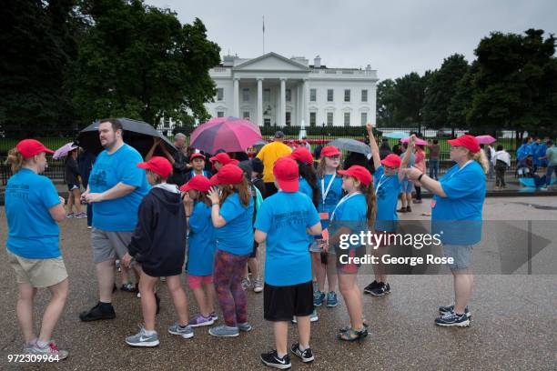 Group of school kids take pictures on the mall in front of The White House in the pouring rain on June 3, 2018 in Washington, D.C. The nation's...